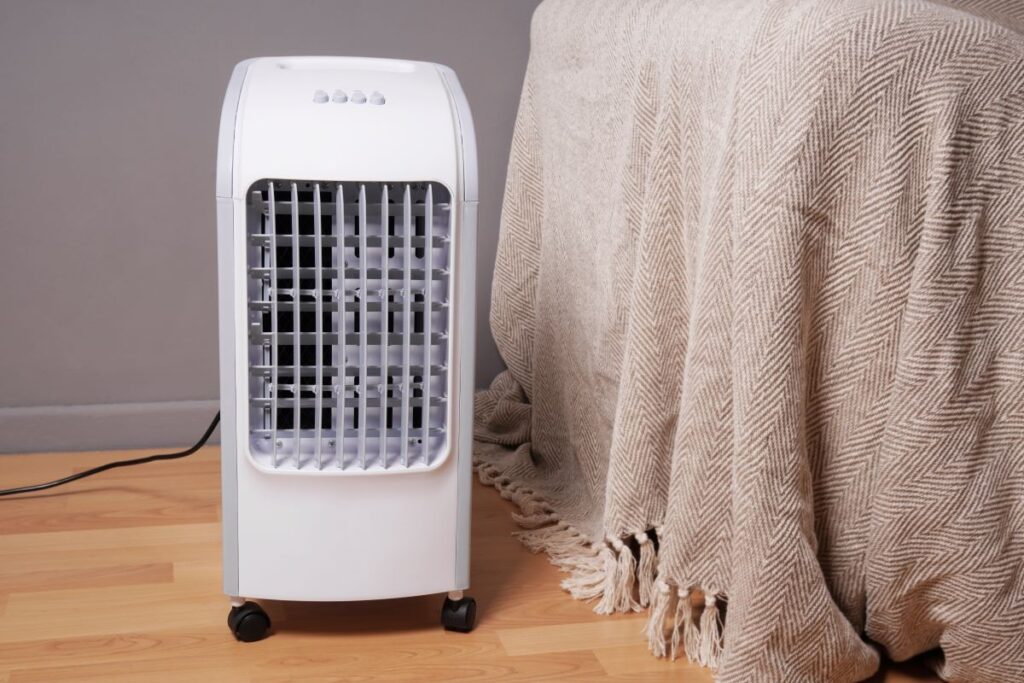 A clean, portable swamp cooler on a wooden floor indoors, highlighting a unit used for home comfort.