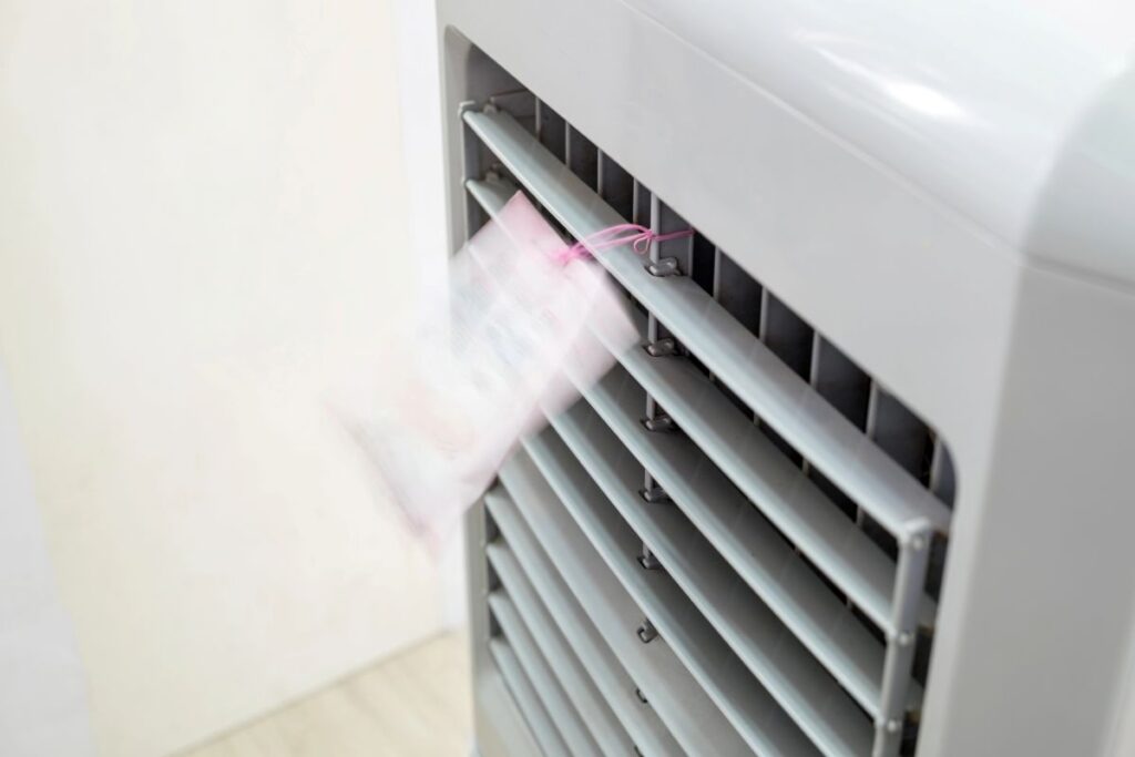 A piece of paper blowing from a swamp cooler vent, indicating it might not be blowing cold air.