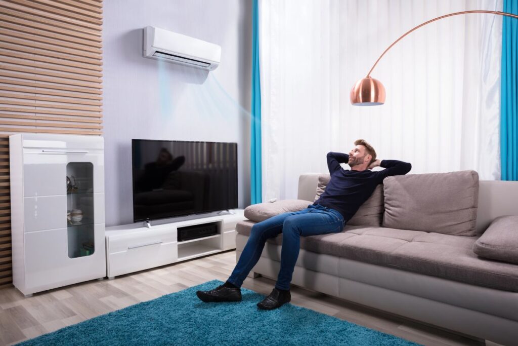 A young man breathing in a room with an optimized HVAC throwing clean air, showing the importance of indoor air quality.