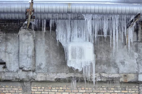 An air conditioner freezing up outisde a house, representing the importance of knowing what to do if an AC is freezing up.