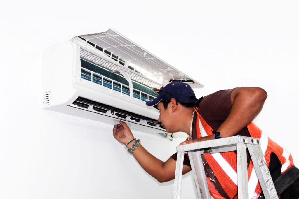 Mini split installer working in a home installation, showing the importance of knowing the mini split installation cost.