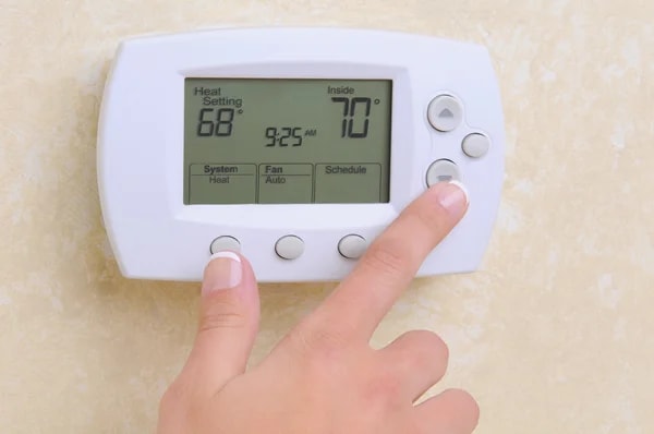 An indoor digital thermostat with a comfortable temperature, showing the best thermostat setting for summer in Arizona.